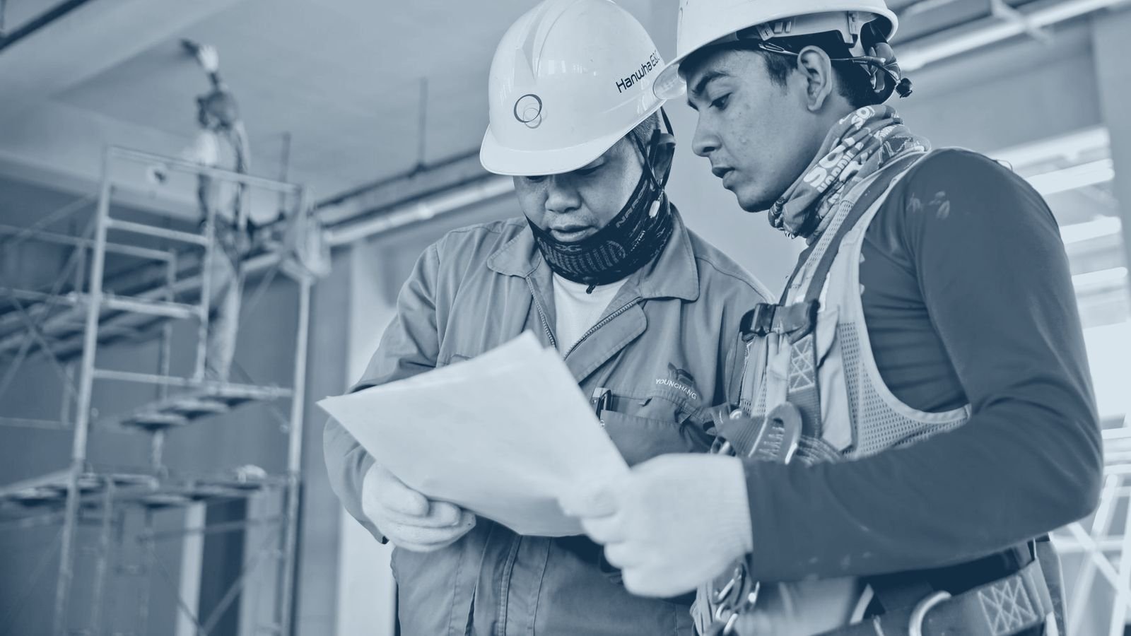 Two construction workers reviewing drawings on site